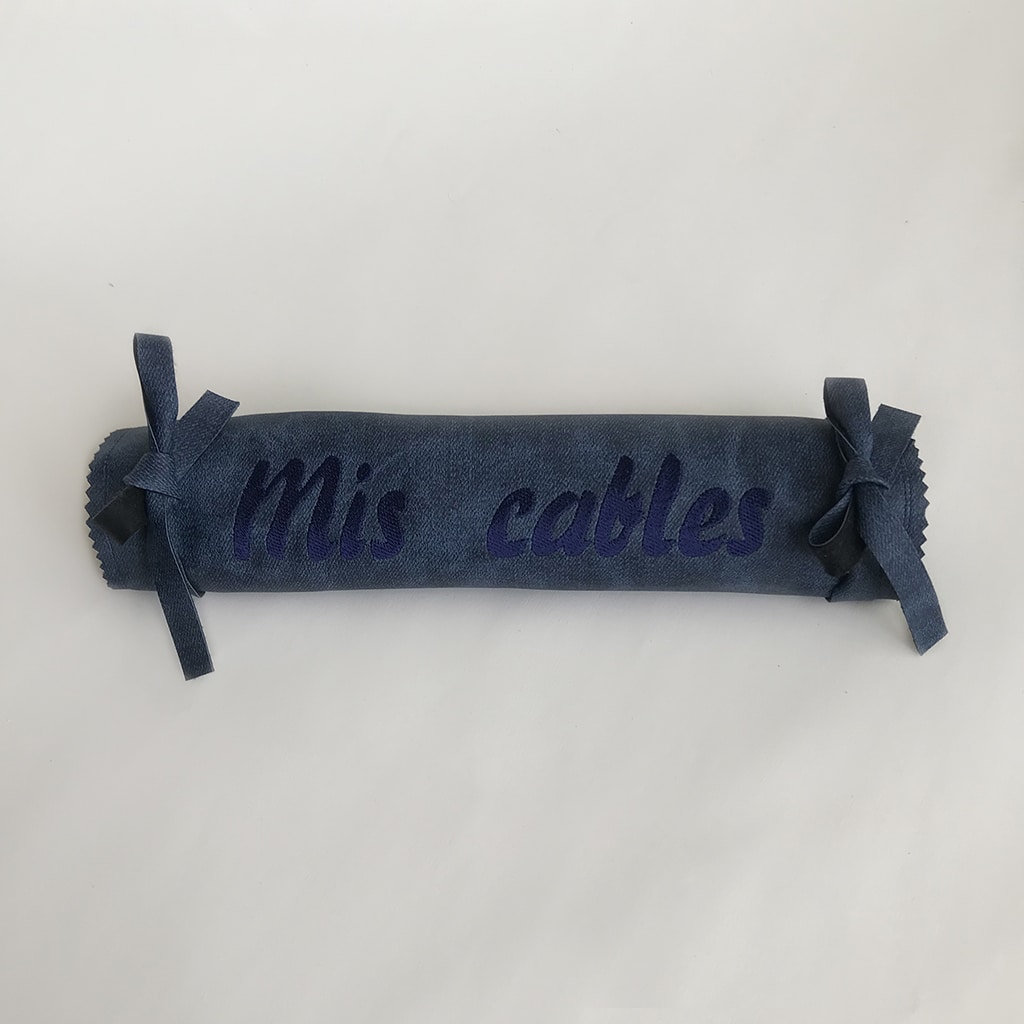 organizador de cables portátiles realizado con polipiel y personalizado con bordado del mismo tono azul y cerrado con lazos a los laterales