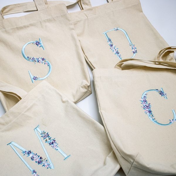 totebags con iniciales bordadas con detalle de flores