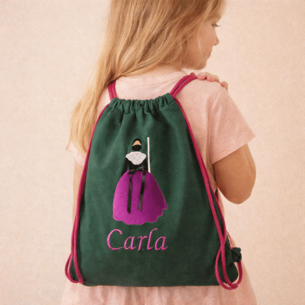 niña con mochila castellonera bordada y con nombre carla bordado
