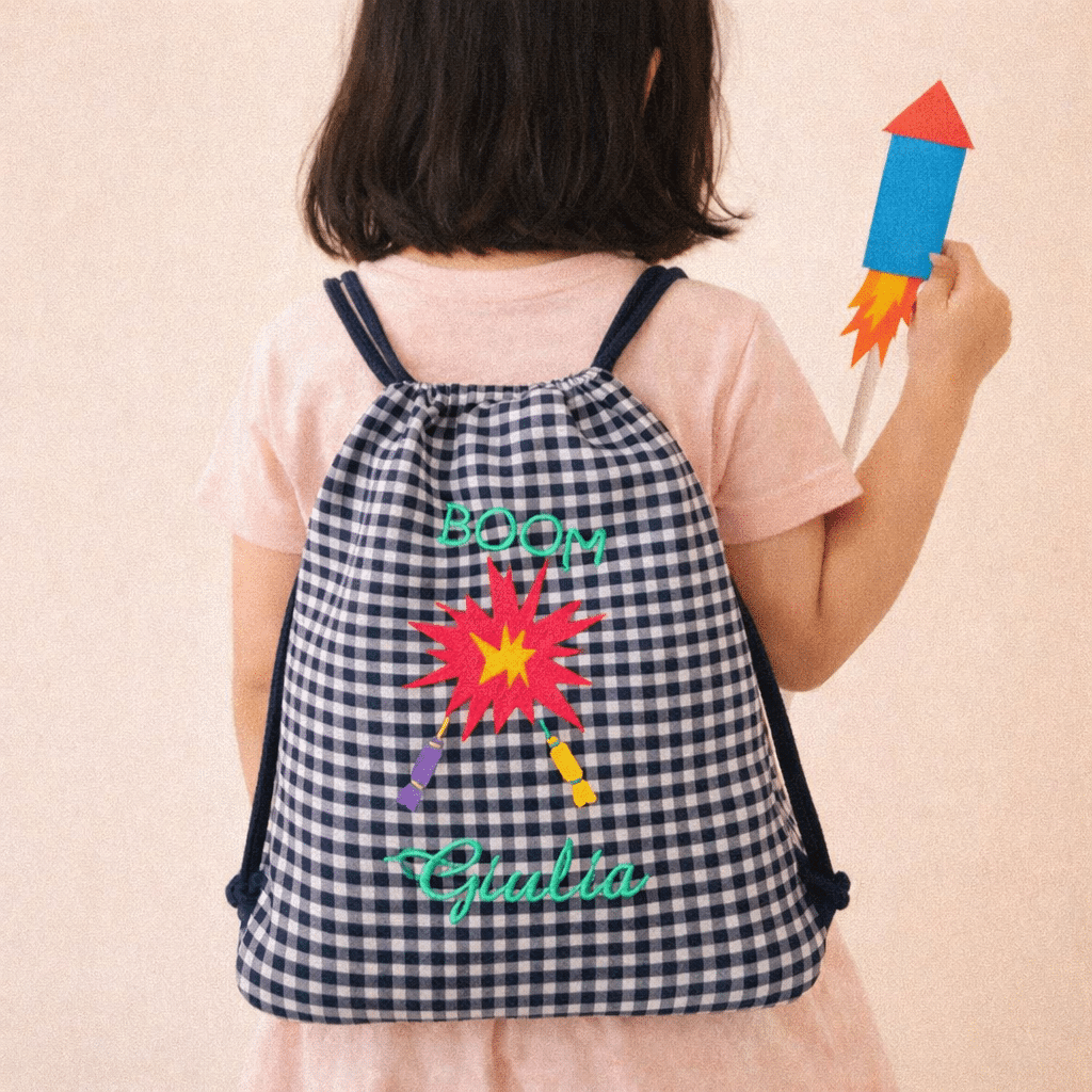 niña con mochila cohetes bordados y cohete de cartón de juguete en la mano